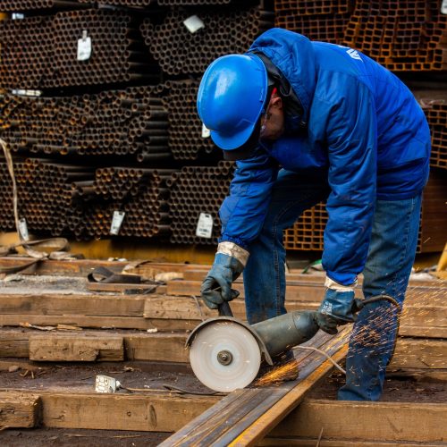 worker cuts iron with tool